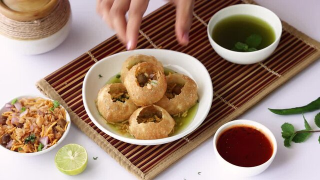Girl women eating serving Pani puri golgappe with hand Chat item India. North Indian street food Indian panipuri snack 4K footage video tamarind water potato stuffing Delhi Mumbai Holi Diwali Dussehra