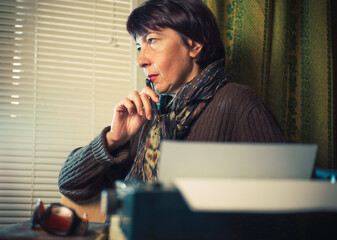Vintage female writer reporter working behind his desk