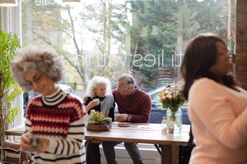 Smiling active senior couple enjoying coffee at  cafe