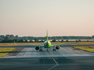 The plane before takeoff. White plane is on takeoff in the morning.