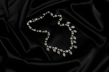 Necklace with diamonds on black background with copy space