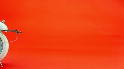 Back to school and teachers day concepts Business objects of White alarm clock with teacher glasses Stop motion animation movement objects on colorful paper background Copy space Seamless loop - Powered by Adobe