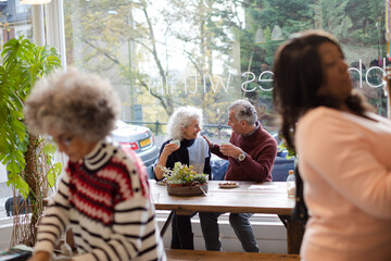 Smiling active senior couple enjoying coffee at  cafe