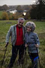Smiling, affectionate senior couple with walking sticks
