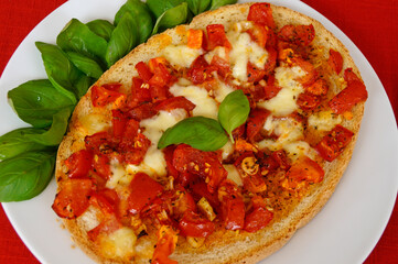 delicious large Italian bruschetta with mozzarella, garlic, olive oil and basil leaves on a plate