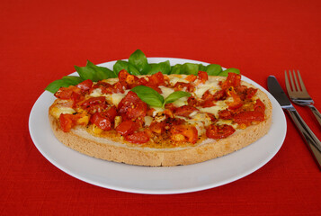 delicious large Italian bruschetta with juicy red tomatoes, mozzarella, garlic, olive oil and fresh basil leaves on a plate	