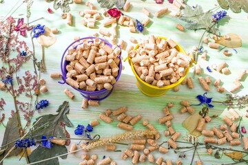 Wooden pellets on a wooden background, eco-friendly product