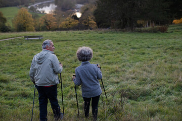 Affectionate senior couple wih walking sticks