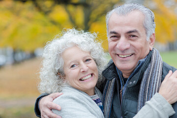 Portrait smiling, affectionate senior couple hugging in park