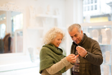 Smiling senior woman with husband in jewelry store