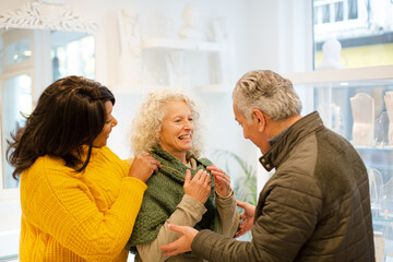 Sales assistant helping senior couple jewelry shopping