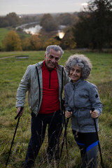 Smiling, affectionate senior couple with walking sticks