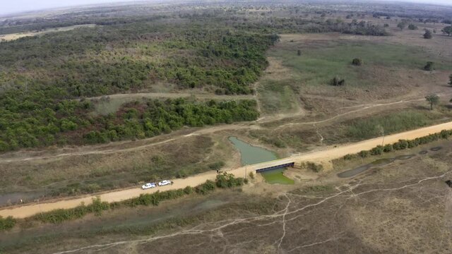 The Brazilian Pantanal wetlands suffering from severe drought with many caiman alligators clustered around a small pond - aerial tilt down flyby