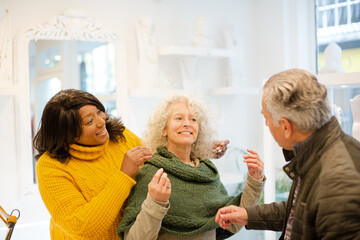 Sales assistant helping senior couple jewelry shopping