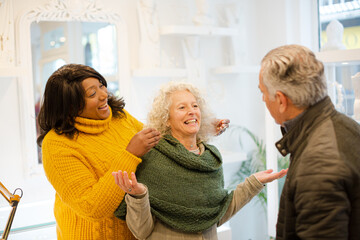 Sales assistant helping senior couple jewelry shopping