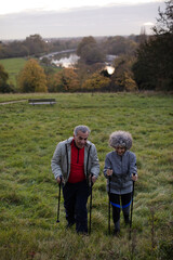 Smiling, affectionate senior couple wih walking sticks