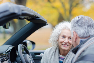 Smiling, affectionate senior couple talking in car