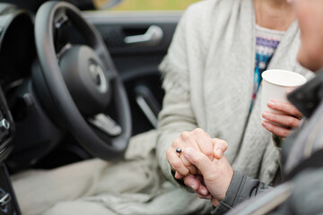 Affectionate senior couple holding hands in car