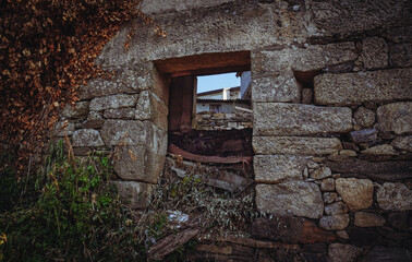 Entrada de una casa de piedra abandonada y en ruinas de un pueblo rural en Galicia.