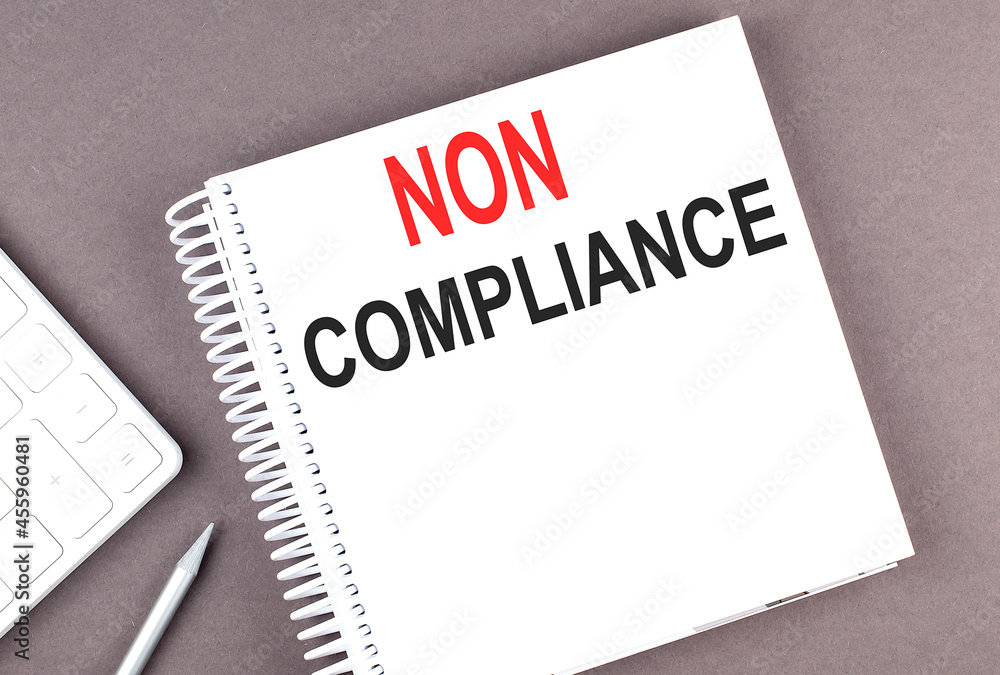 Poster non compliance text on the notebook with calculator and pen