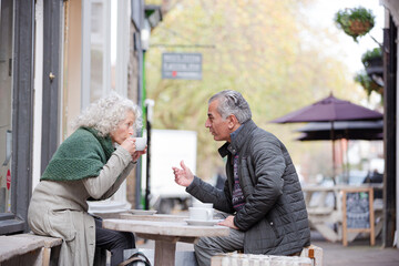 Senior couple drinking coffee at sidewalk cafe