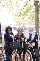Naklejka premium Portrait confident, smiling senior women bike riding in autumn park