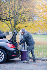 Obraz premium Smiling, affectionate senior couple with suitcases