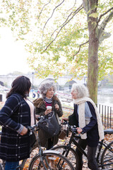 Portrait confident, smiling senior women bike riding in autumn park