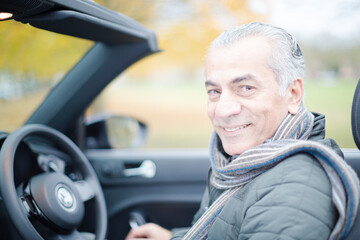 Smiling, affectionate senior man in car