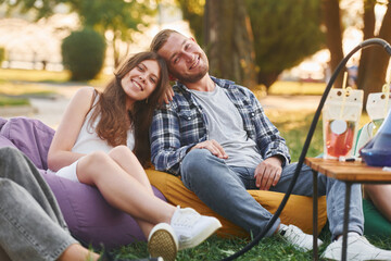 Fototapeta na wymiar Happy couple. Group of young people have a party in the park at summer daytime