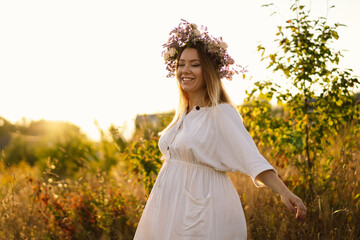 Fototapeta na wymiar Portrait of a pregnant woman. A beautiful young pregnant woman in a white dress walks in the field. Happy pregnancy. Concepts of pregnancy. Romantic mood. Nature lover.