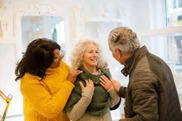 Sales assistant helping senior couple jewelry shopping