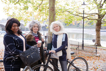 Obraz na płótnie Canvas Portrait confident, smiling senior women bike riding in autumn park