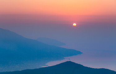 Obraz premium Sunrise overlooking the sea in the haze in the mountains