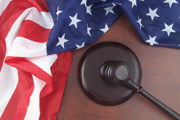Wooden judge gavel and USA flag. Laws and court of US concept.	