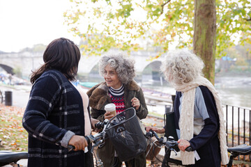 Portrait confident, smiling senior women bike riding in autumn park