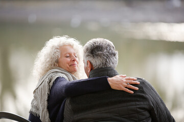 Affectionate, tender senior couple hugging in autumn park