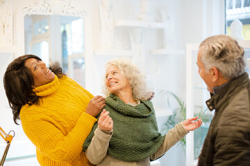 Sales assistant helping senior couple jewelry shopping