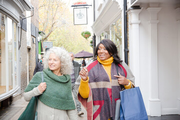 Senior women friends window shopping outside storefront