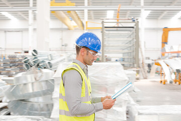 Male supervisor with paperwork walking in steel factory