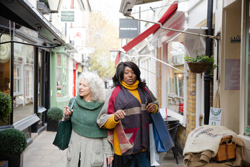 Senior women friends window shopping outside storefront