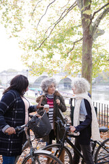 Portrait confident, smiling senior women bike riding in autumn park