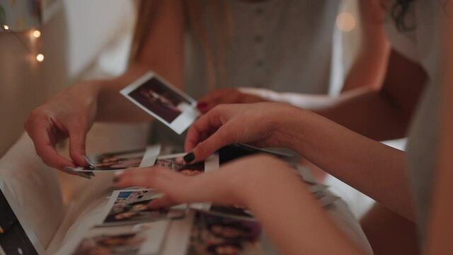 happy teen girls looking at photos at home having fun sharing memories hanging out together