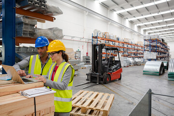 Managers using laptop in factory