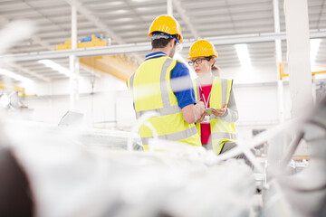 Smiling female worker talking with coworkers in factory