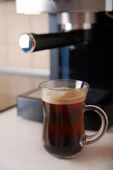 Two transparent cups coffee close-up front view. Home coffee maker and process of making coffee drink.
