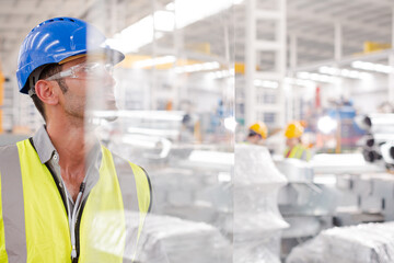 Male worker looking away on platform in factory