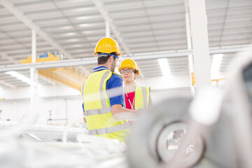 Smiling female worker talking with coworkers in factory