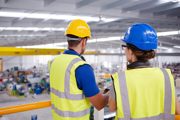 Supervisor and worker talking in steel factory