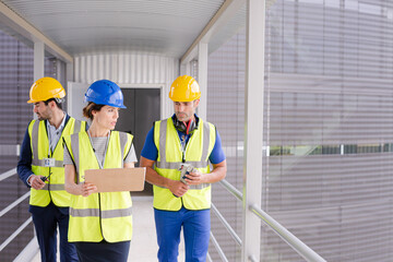Supervisors and worker with clipboard talking in factory